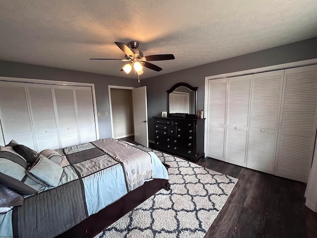 bedroom with a textured ceiling, ceiling fan, and dark hardwood / wood-style floors