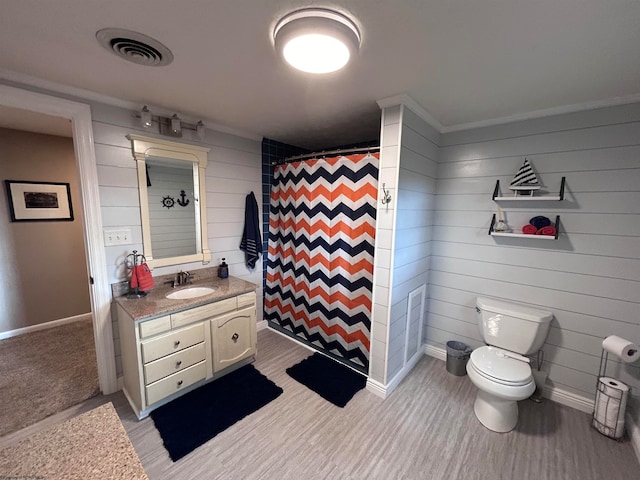 bathroom featuring curtained shower, vanity, wood walls, and toilet