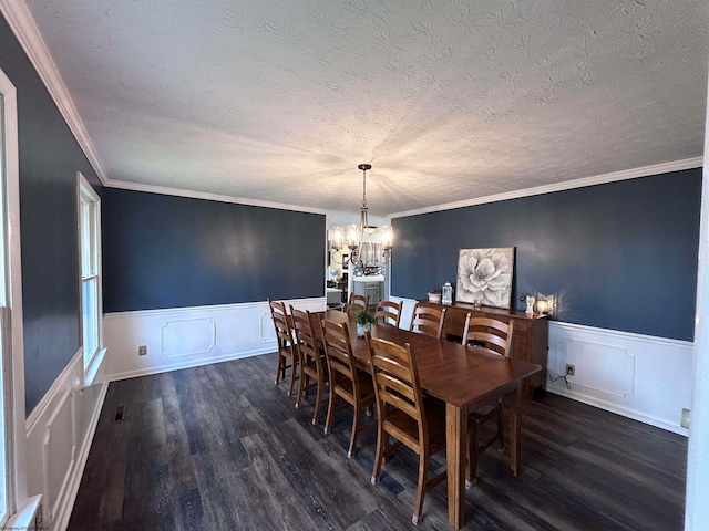 dining space featuring a chandelier, ornamental molding, a textured ceiling, and dark wood-type flooring