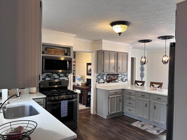 kitchen featuring hanging light fixtures, sink, decorative backsplash, appliances with stainless steel finishes, and dark hardwood / wood-style flooring