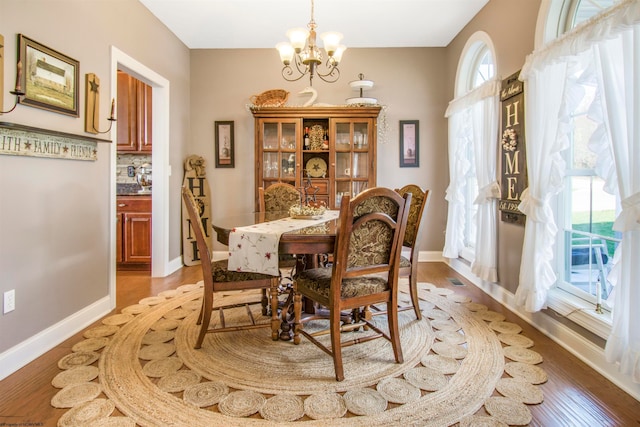 dining room featuring hardwood / wood-style flooring, a wealth of natural light, and an inviting chandelier