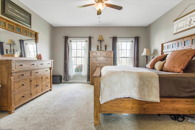 carpeted bedroom featuring multiple windows and ceiling fan