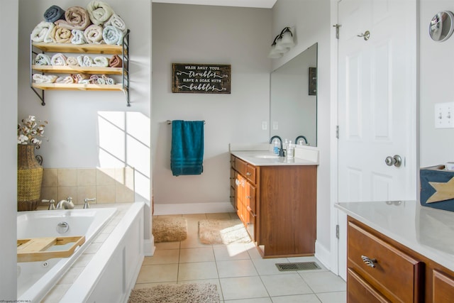 bathroom with tile patterned flooring, vanity, and a relaxing tiled tub