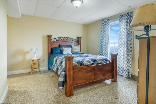 bedroom with light carpet and a drop ceiling