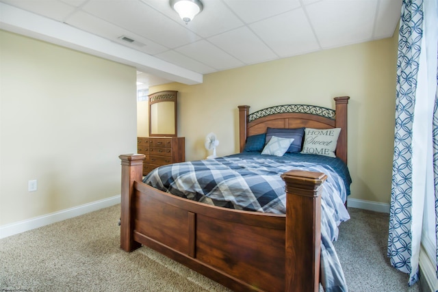 bedroom featuring carpet floors and a drop ceiling