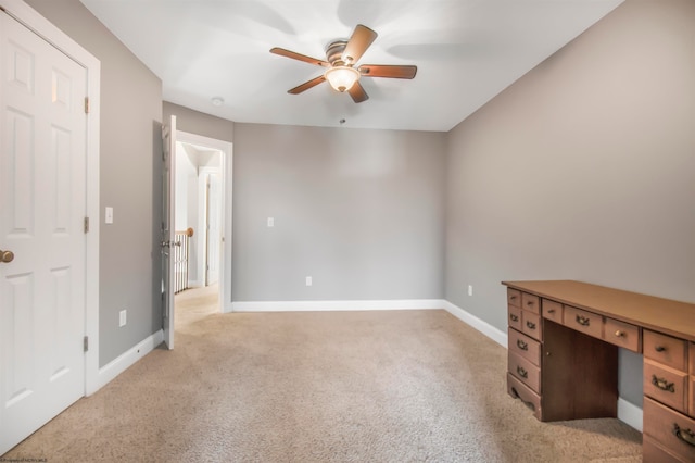 empty room featuring ceiling fan and light colored carpet