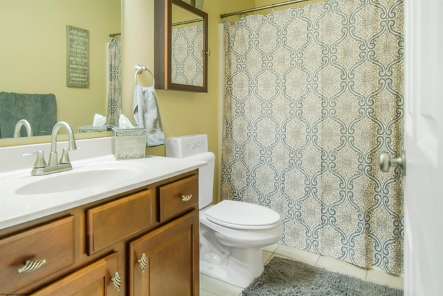 bathroom with toilet, vanity, and tile patterned floors