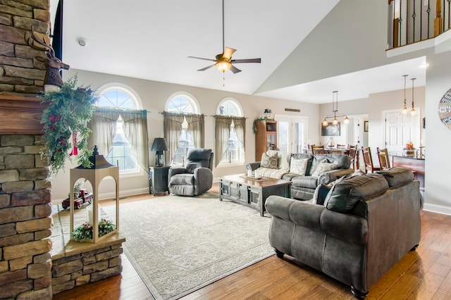 living room featuring ceiling fan, high vaulted ceiling, and wood-type flooring