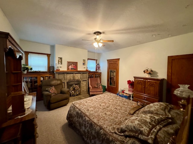 bedroom with ceiling fan, light colored carpet, and a brick fireplace