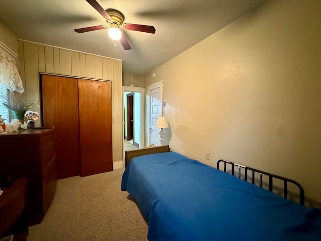 bedroom featuring ceiling fan, a closet, and light carpet