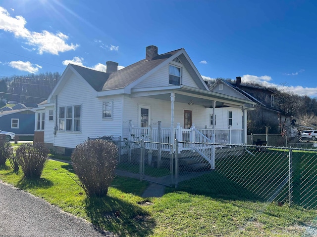 bungalow-style house featuring covered porch and a front yard