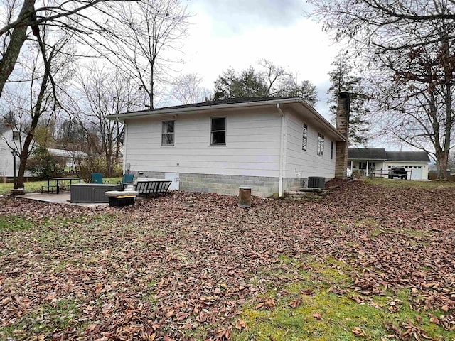 view of side of home featuring a patio and central AC