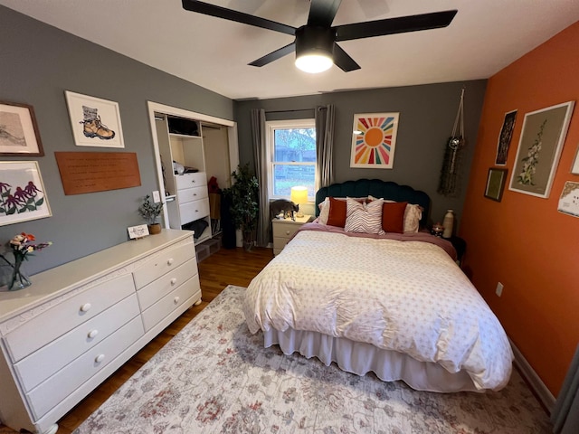 bedroom featuring dark hardwood / wood-style flooring, ceiling fan, and a closet