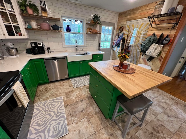 kitchen featuring backsplash, range with electric cooktop, green cabinetry, dishwasher, and a breakfast bar area