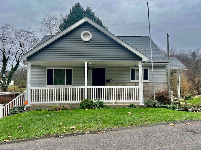 view of front of house with covered porch, ceiling fan, and a front yard