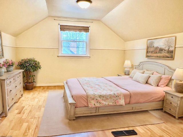 bedroom featuring light hardwood / wood-style flooring and lofted ceiling