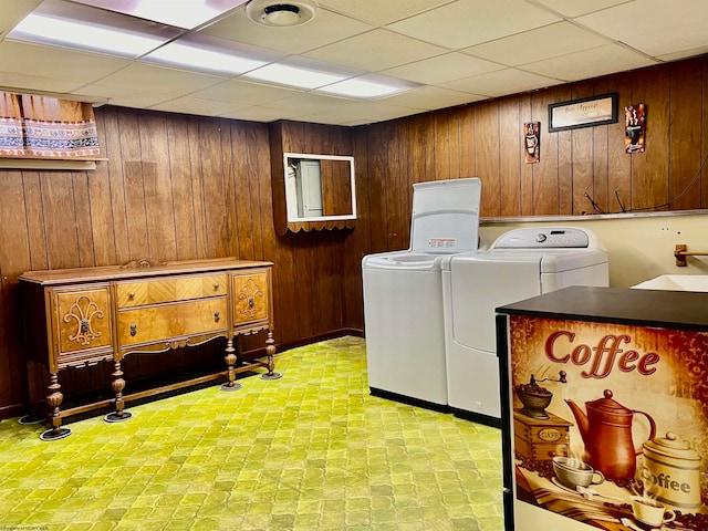 laundry area featuring independent washer and dryer, wooden walls, and sink