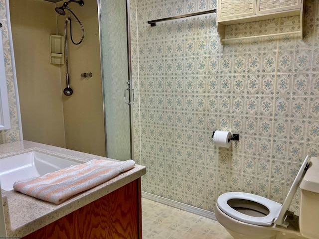 bathroom with vanity, toilet, and a shower with door