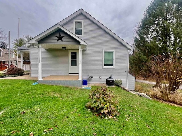 rear view of house with a lawn and central AC unit