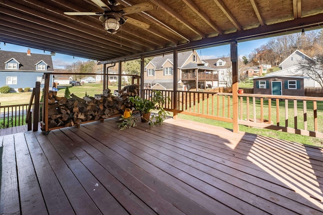 wooden terrace featuring an outdoor structure and a lawn