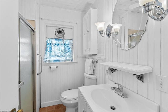 bathroom featuring tile patterned flooring, vanity, toilet, and wooden walls