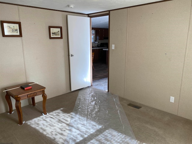 hallway with carpet and ornamental molding