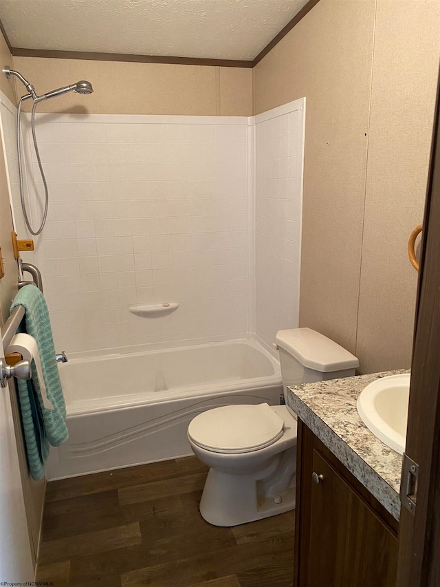 full bathroom featuring a textured ceiling, vanity, shower / washtub combination, hardwood / wood-style flooring, and toilet