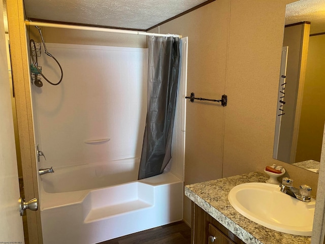 bathroom with vanity, shower / bathtub combination with curtain, and a textured ceiling