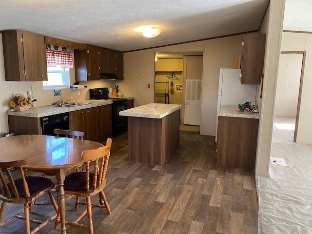 kitchen with dark wood-type flooring, black appliances, sink, a textured ceiling, and a kitchen island