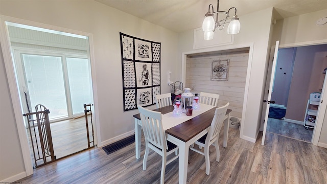 dining area featuring a chandelier and wood-type flooring