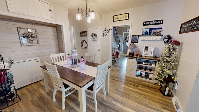 dining space featuring light hardwood / wood-style flooring and a notable chandelier