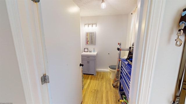 bathroom with vanity, wood-type flooring, a textured ceiling, and toilet