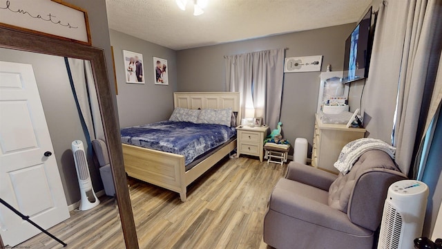 bedroom with light hardwood / wood-style flooring and a textured ceiling