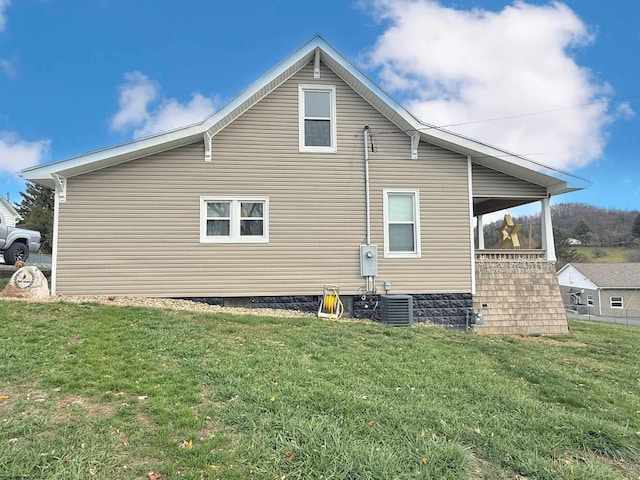 view of home's exterior featuring central AC unit and a yard