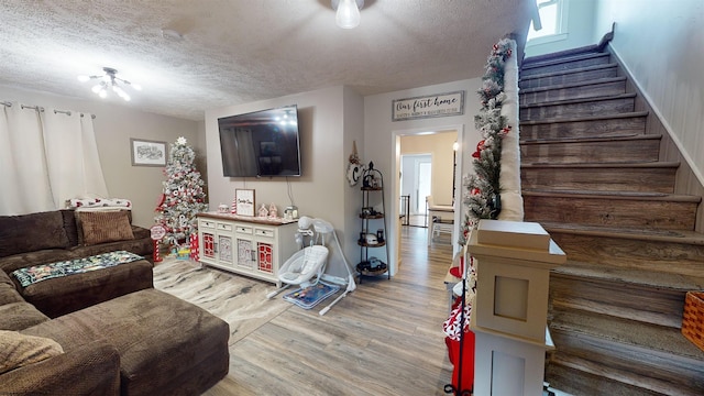 living room with light wood-type flooring and a textured ceiling