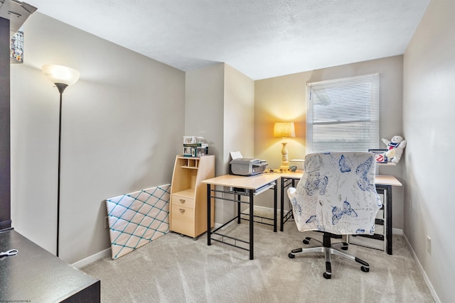 carpeted home office featuring a textured ceiling