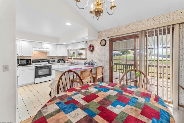 dining area with vaulted ceiling, sink, and a chandelier