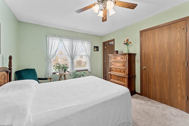 bedroom with a closet, light colored carpet, and ceiling fan