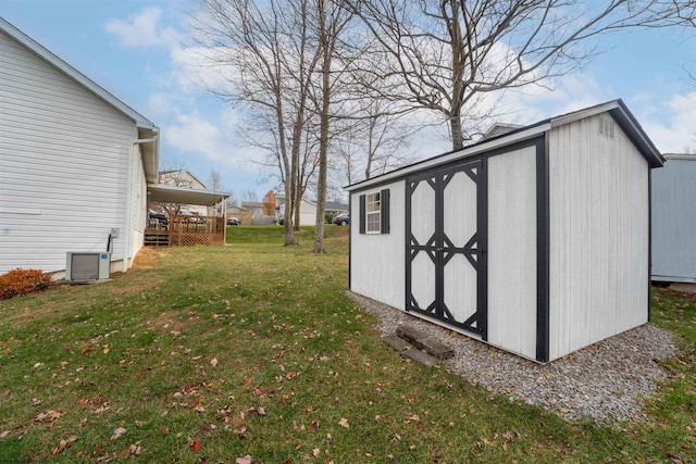 view of outbuilding with central air condition unit and a lawn