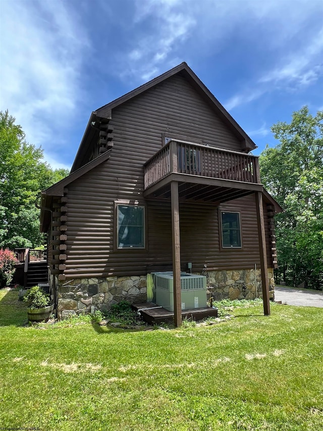 back of house with central air condition unit, a wooden deck, a balcony, and a yard