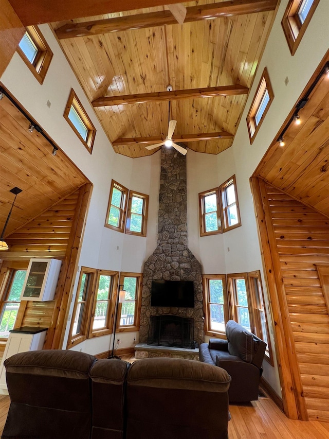 living room with high vaulted ceiling, ceiling fan, a fireplace, light hardwood / wood-style floors, and wood ceiling