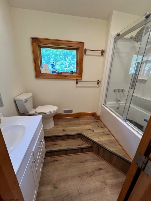 full bathroom featuring vanity, hardwood / wood-style flooring, and enclosed tub / shower combo