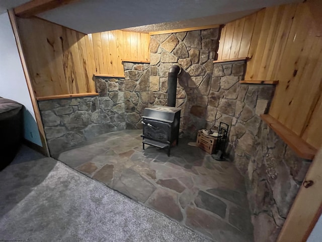 interior details featuring a wood stove and wooden walls