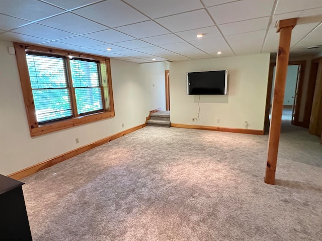 basement with a paneled ceiling and carpet floors