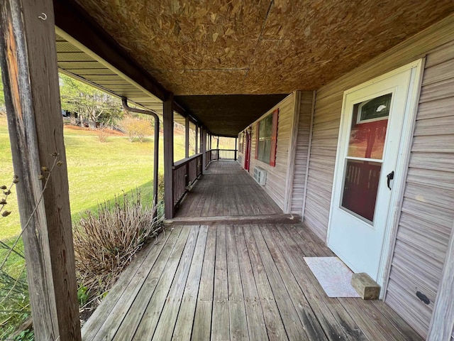 deck with covered porch and a yard