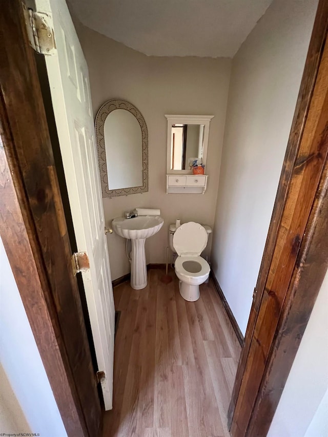 bathroom with toilet and wood-type flooring