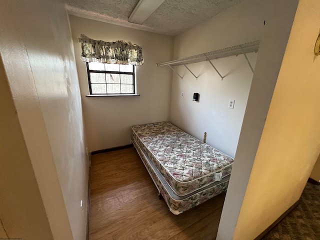 bedroom with wood-type flooring and a textured ceiling