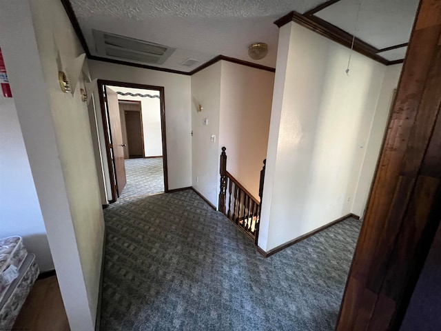 hallway with dark colored carpet, crown molding, and a textured ceiling