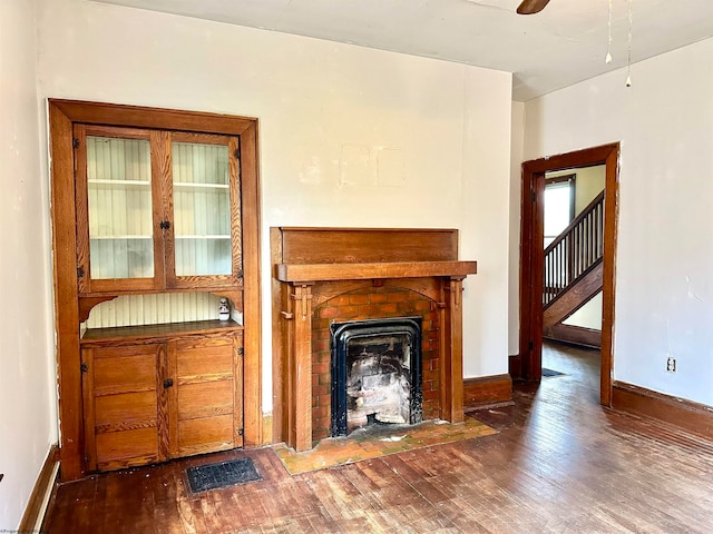 unfurnished living room featuring ceiling fan and dark hardwood / wood-style flooring