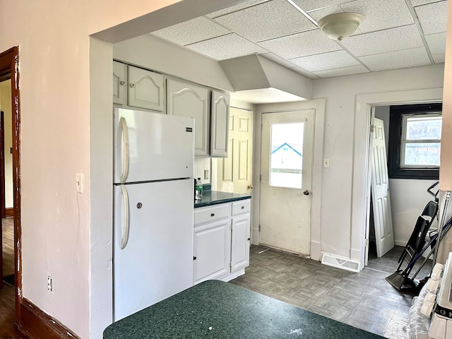 kitchen featuring white cabinets, white fridge, and a healthy amount of sunlight